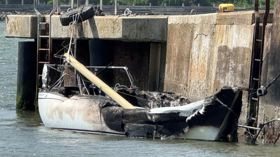 Burnt out boat on the water