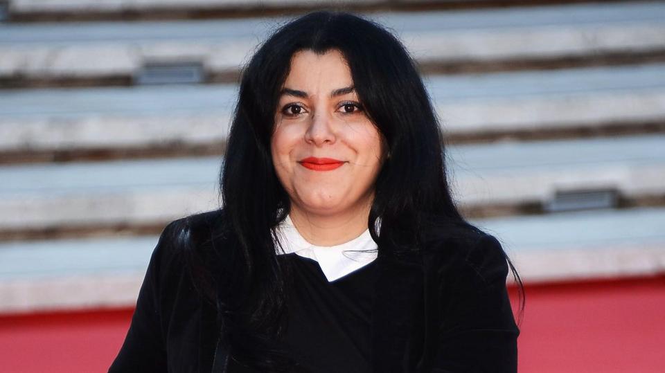 Marjane Satrapi smiling at the camera while wearing a black jacket