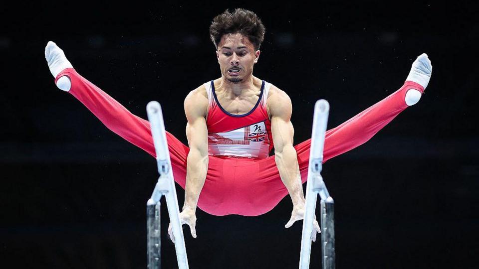 Jake Jarman performs on the parallel bars