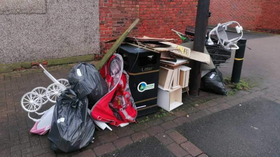 A pile of rubbish next to a bin 