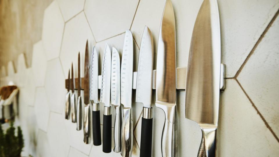 Kitchen knives hang on a wall