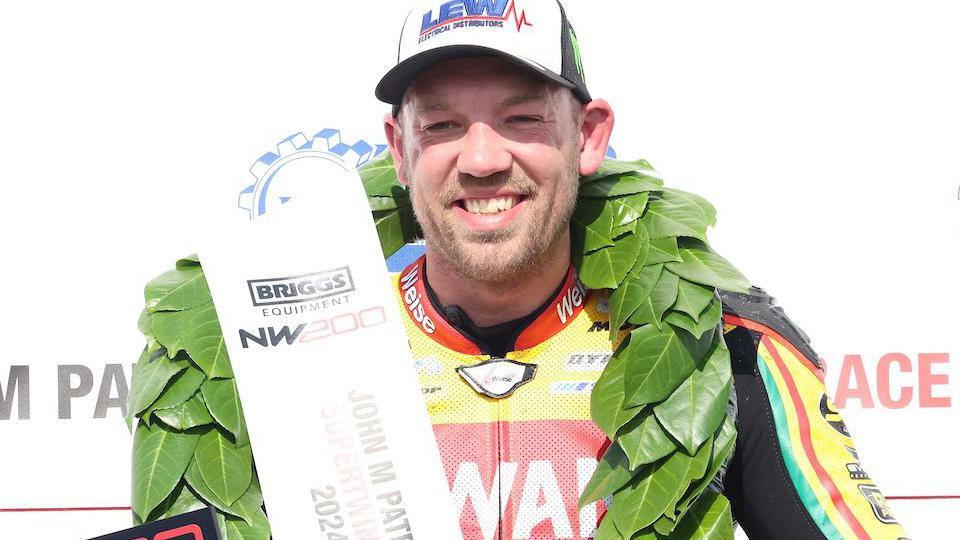 Peter Hickman stands on top of the rostrum at the North West 200