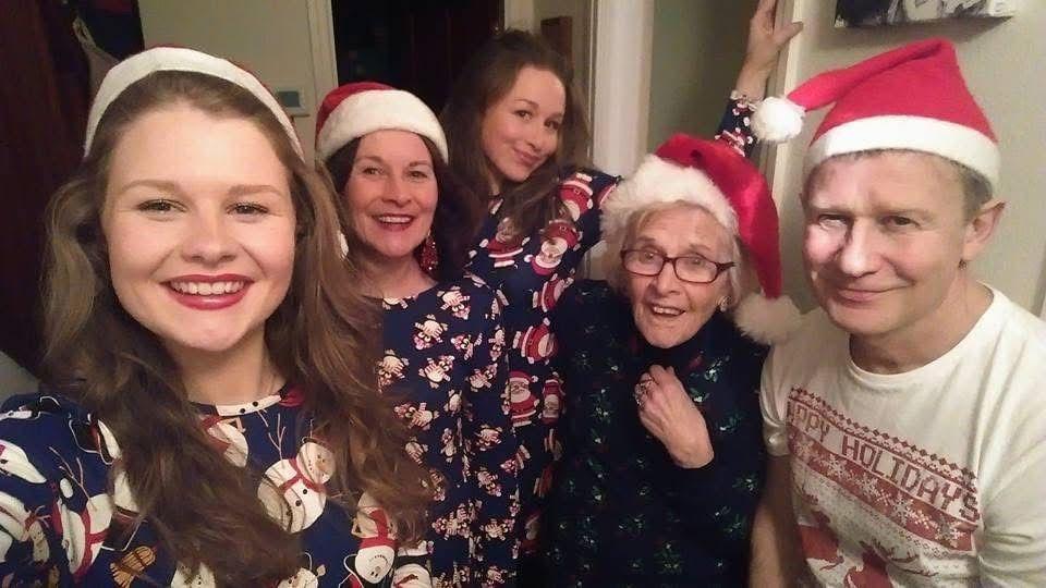 Jo Henwood with her daughters, mother and husband, wearing Christmas hats and pyjamas 