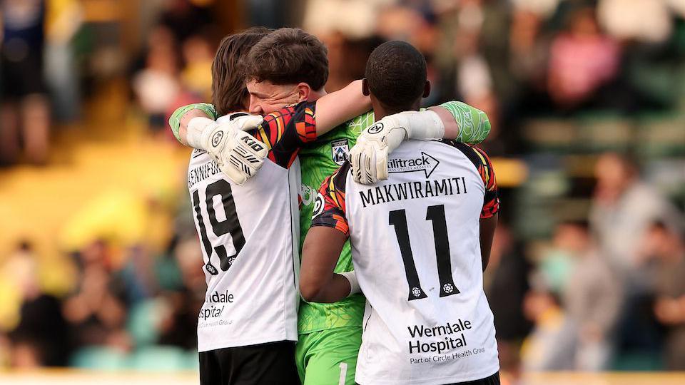 Haverfordwest goalkeeper Ifan Knott is congratulated by team-mates after the penalty shoot-out win over Barry Town