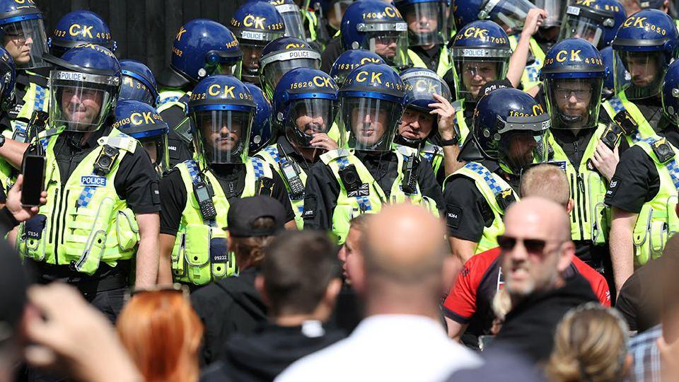 Police officers stand guard during a protest in Manchester 