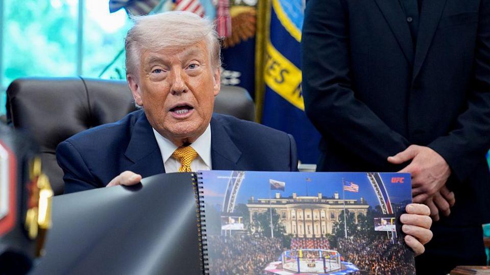 Donald Trump hols up a rendered image of the UFC's White House event