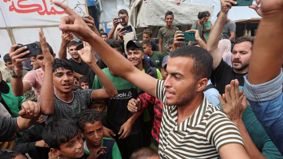 Palestinians celebrate, after U.S. President Donald Trump announced that Israel and Hamas agreed on the first phase of a Gaza ceasefire, in Khan Younis in the southern Gaza Strip October 9, 2025. REUTERS/Ramadan Abed