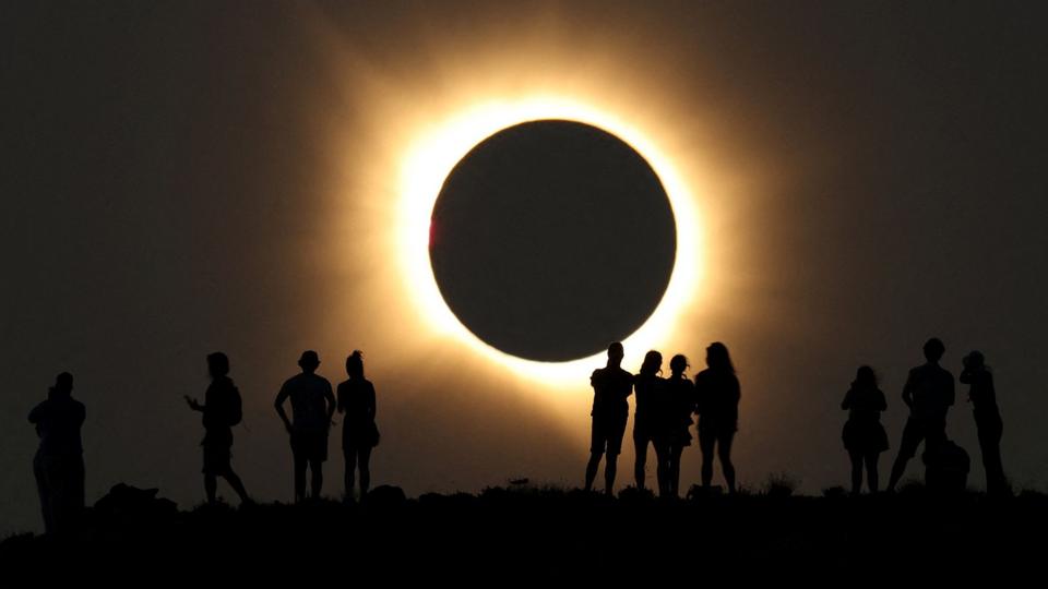 Full eclipse with silhouetted people watching in Arcos de las Salinas, Spain