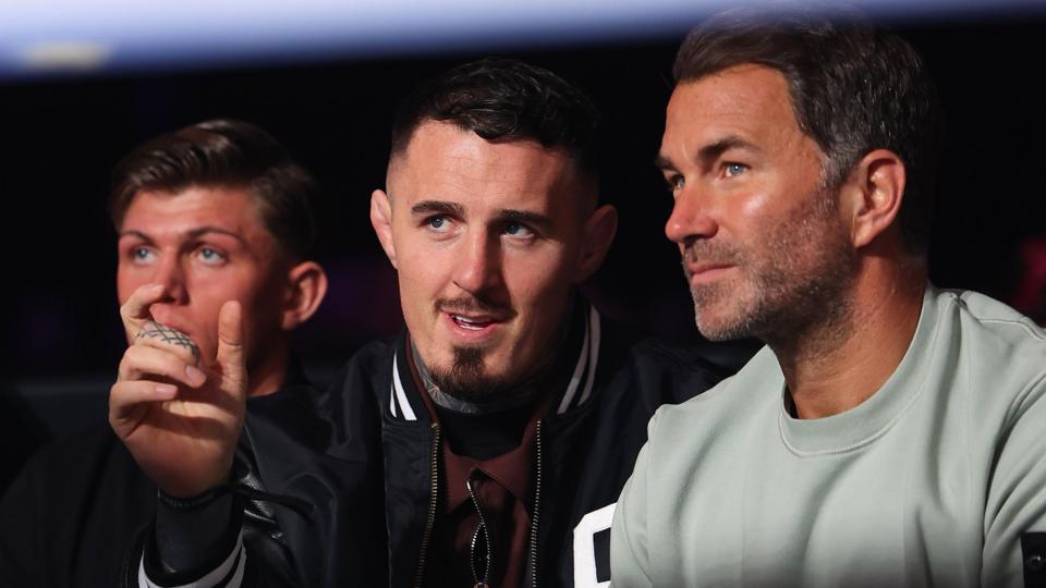 Eddie Hearn and Tom Aspinall talk while they watch a boxing match in April 2026