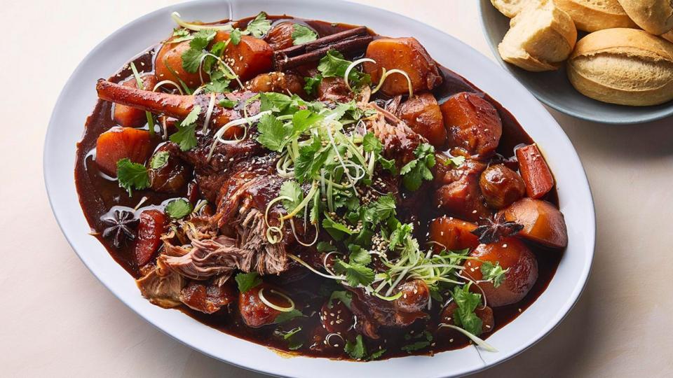 Braised leg of lamb on a plate with vegetables and gravy