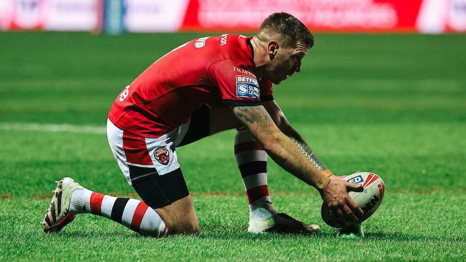 Salford's Marc Sneyd props the ball on the tee waiting to strike at goal