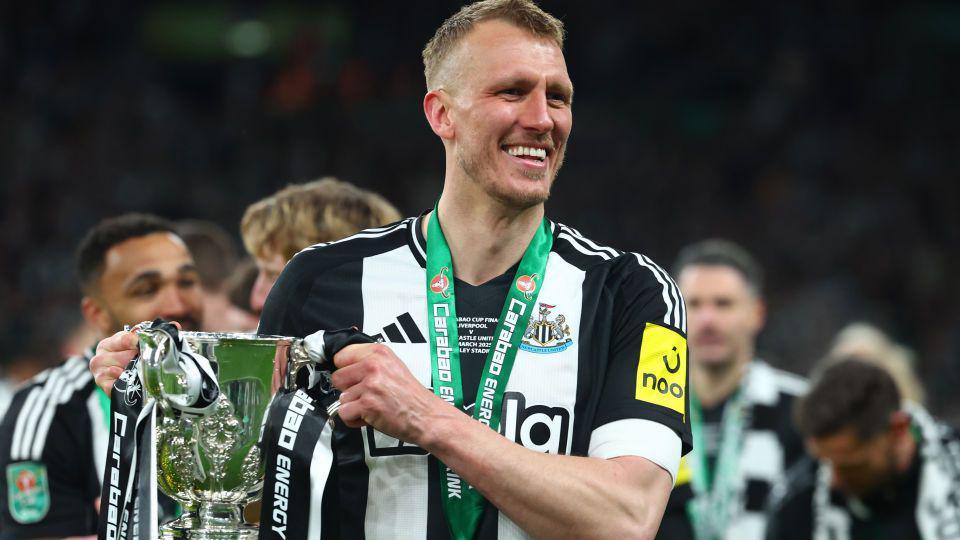 Newcastle United goalscorer Dan Burn lifts The Carabao Cup after victory against Liverpool at Wembley