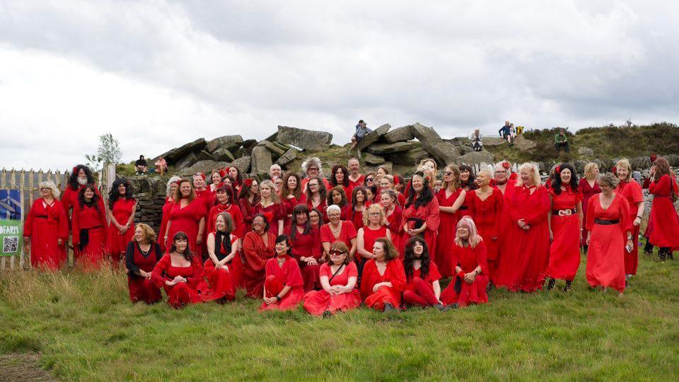 People taking part in a dance on the moors in Yorkshire join for a group photo - all dressed in red 