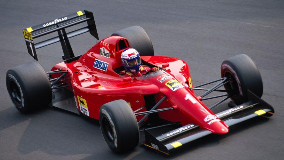 A close-up image of Alain Prost driving the Ferrari 641 during the 1990 Italian Grand Prix at Monza