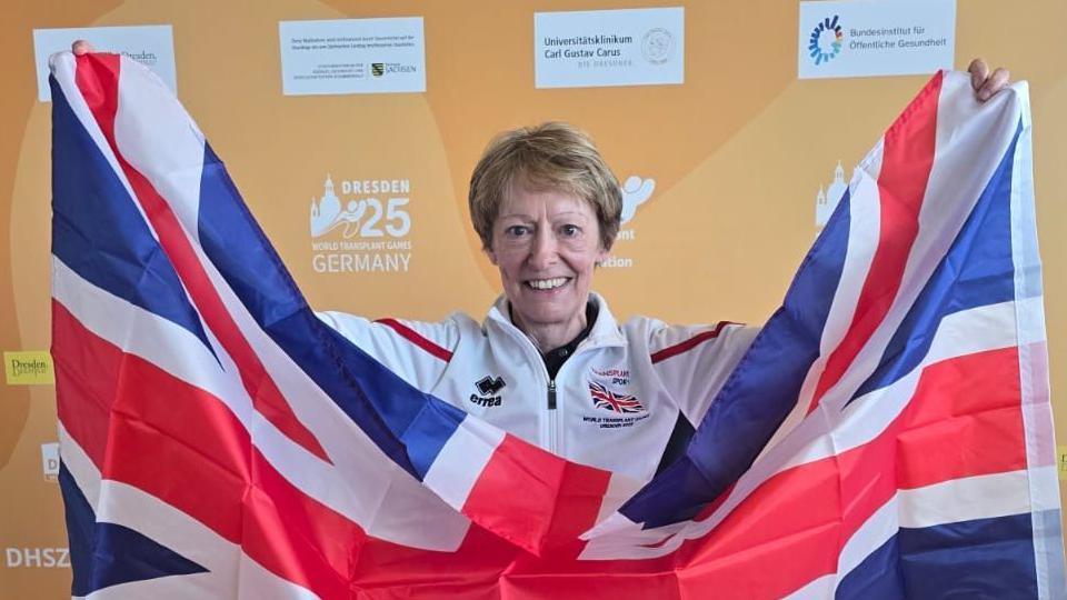 A woman holding the national flag aloft