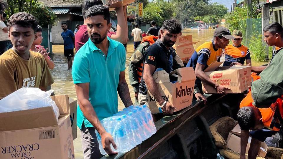 Men unloading boxes of water from a fishing boat