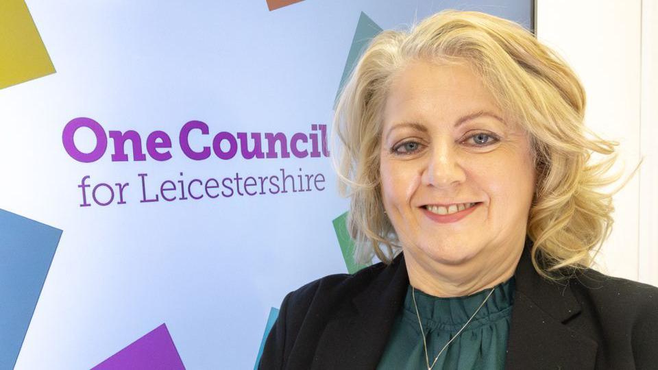 Deborah Taylor standing next to new council branding