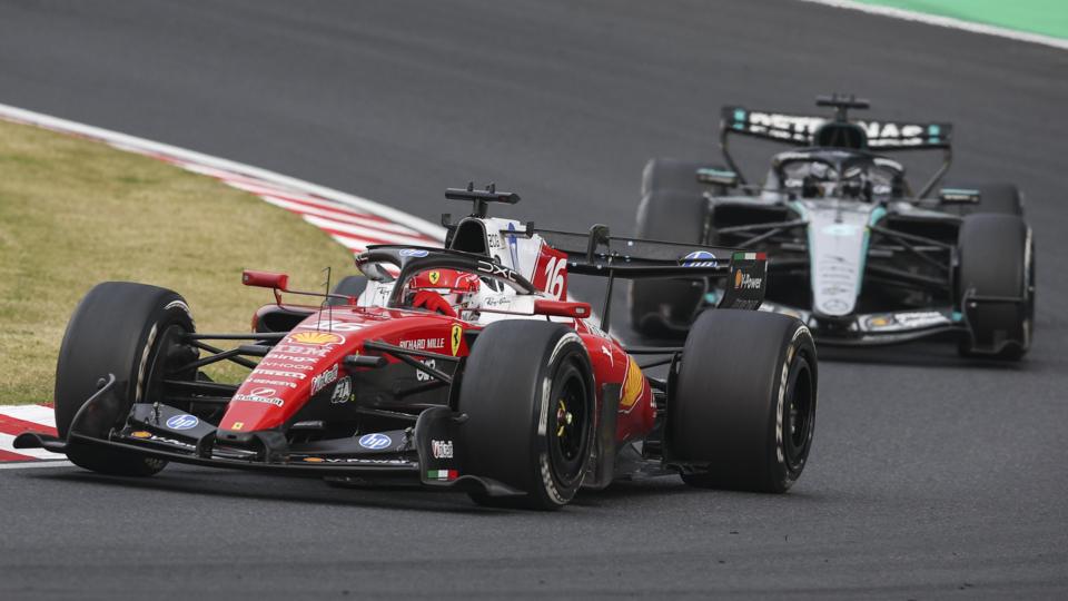Ferrari's Charles Leclerc goes around a right-hand corner during the Japanese Grand Prix with Mercedes' George Russell right behind him