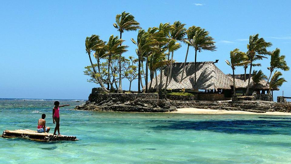 Children float on a bamboo pontoon on the resort-studded Coral Coast of Fiji, 11 November 2003. 