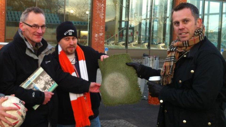 Fans with the penalty spot from Luton Town's artificial pitch