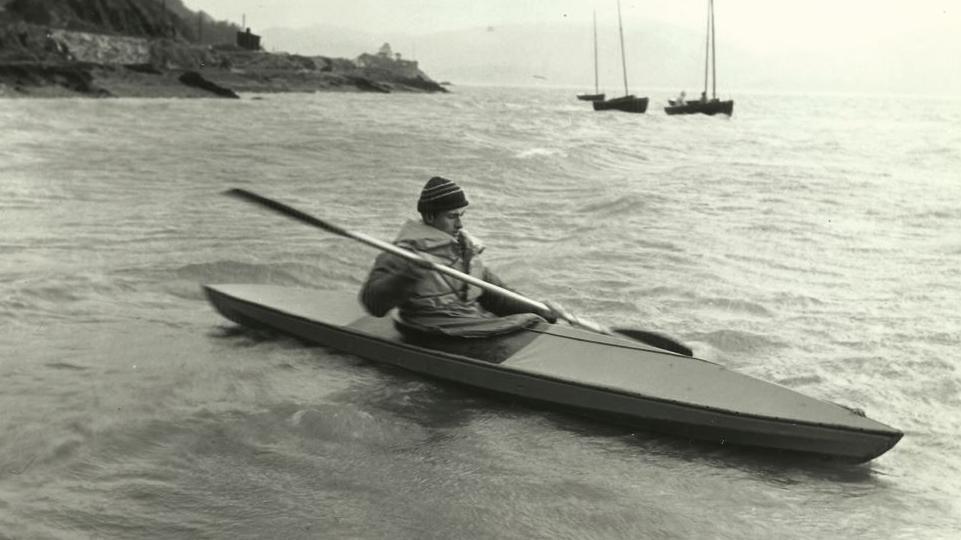 Dyn ifanc mewn canŵ yn Aberdyfi