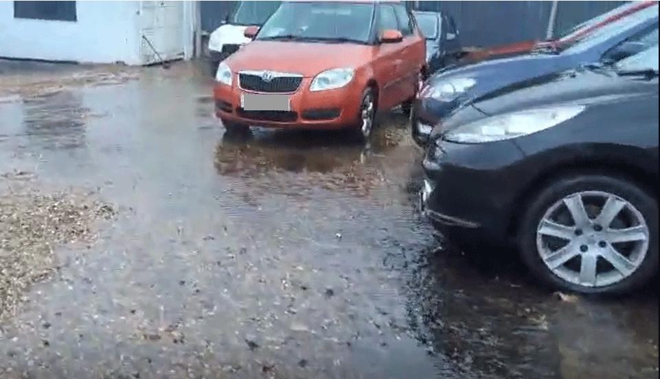 Cars parked on gravel in standing water of about two inches 