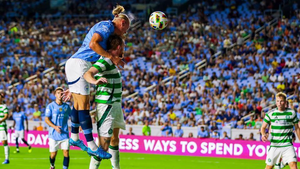 Erling Haaland towers above a defender to score a header