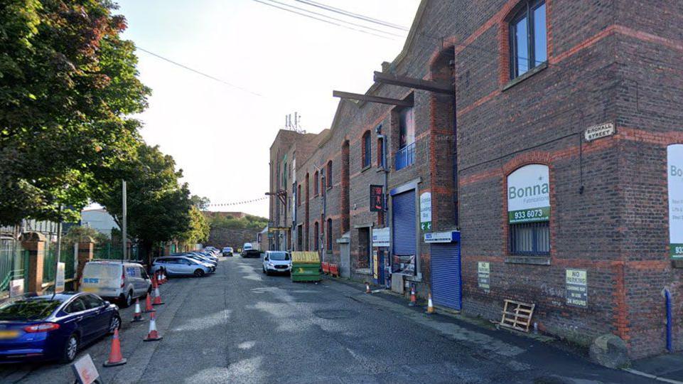 Birchall Street is a brick warehouse style building which is now occupied by a range of businesses. A number of cars are parked on the road outside.