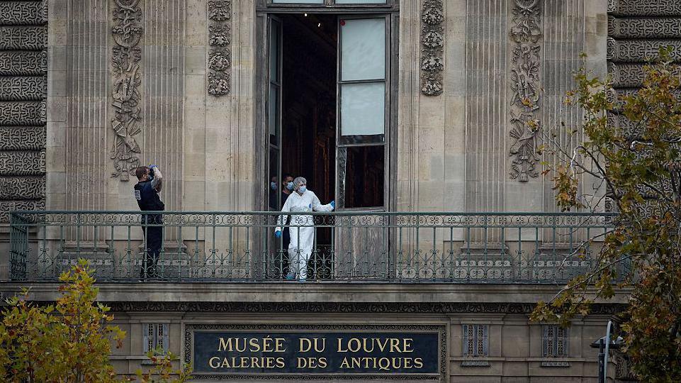 A French Forensics Officer examines the cut window and balcony of a gallery at the Louvre Museum which was the scene of a robbery at the world famous museum earlier in the day on October 19, 2025 in Paris, Franc