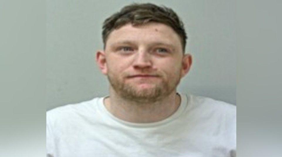 Burba has short brown hair and a whispy brown beard - he is wearing a white T-shirt