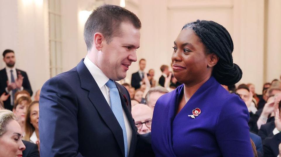 Robert Jenrick shakes Kemi Badenoch's hand to congratulate her after she was announced as the new leader of Britain's Conservative Party