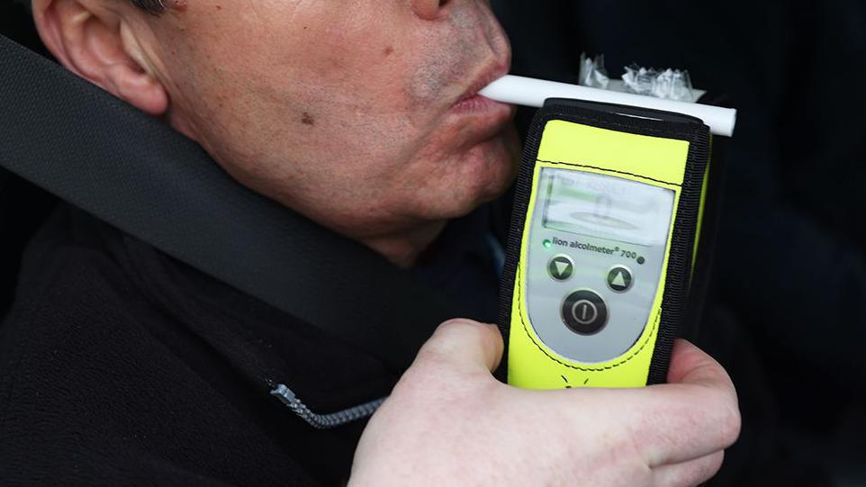 Generic image of a driver blowing into a breathalyser