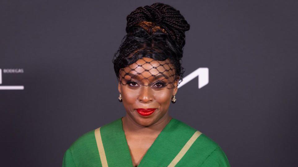 Chimamanda Ngozi Adichie in a hat with a veil and a green top