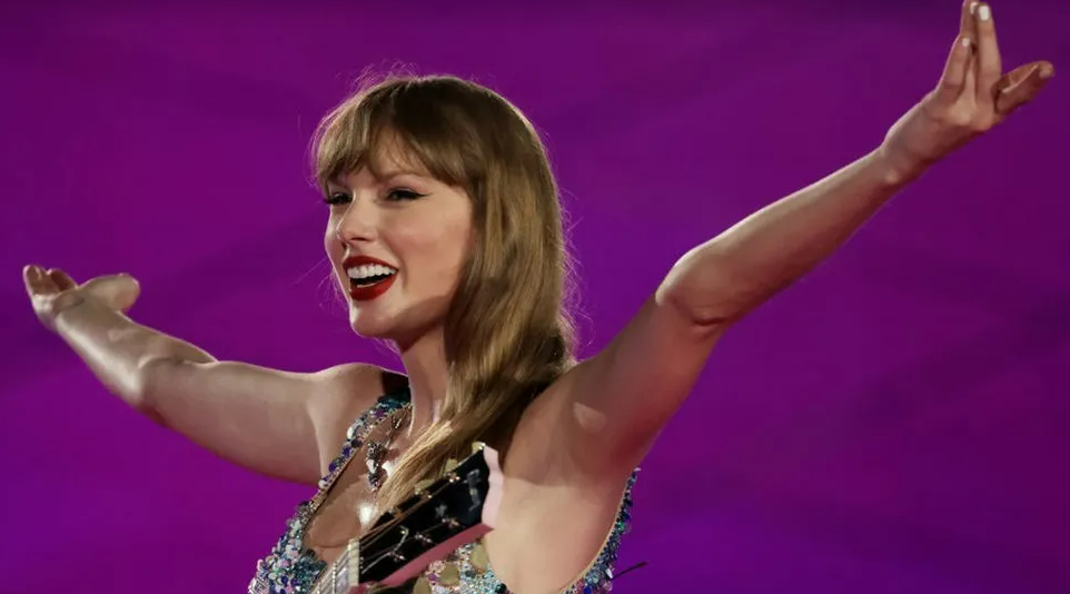 Taylor Swift in front of a purple background 