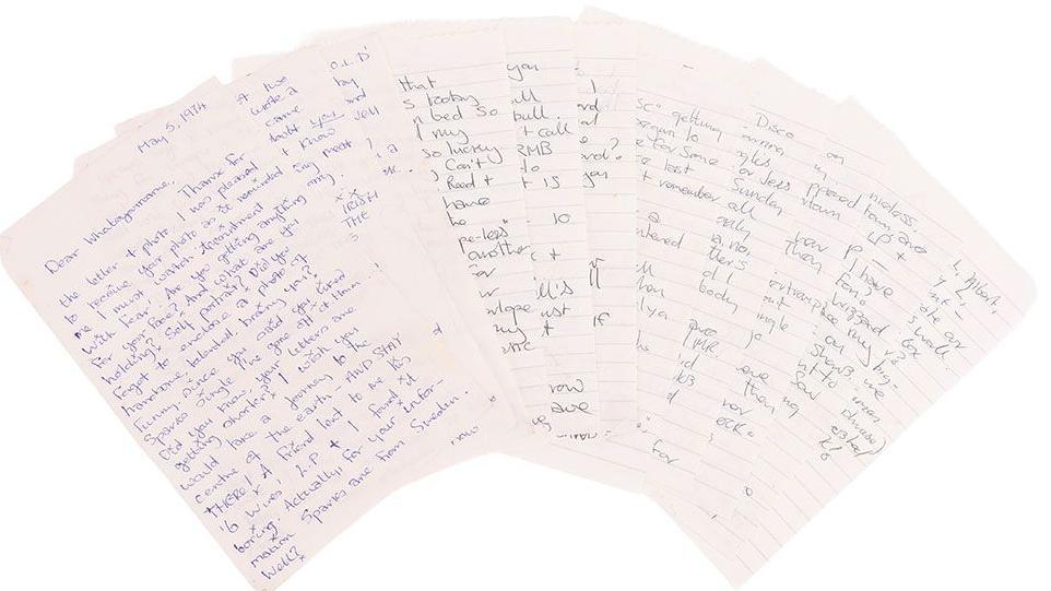 11 or so letters spread out in a fan shape, on white lined paper with blue and black ink and against a plain white background