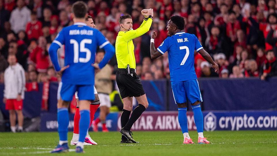 Referee Francois Letexier crosses his arms to indicate the Benfica v Real Madrid game was being stopped due to an allegation of racist abuse