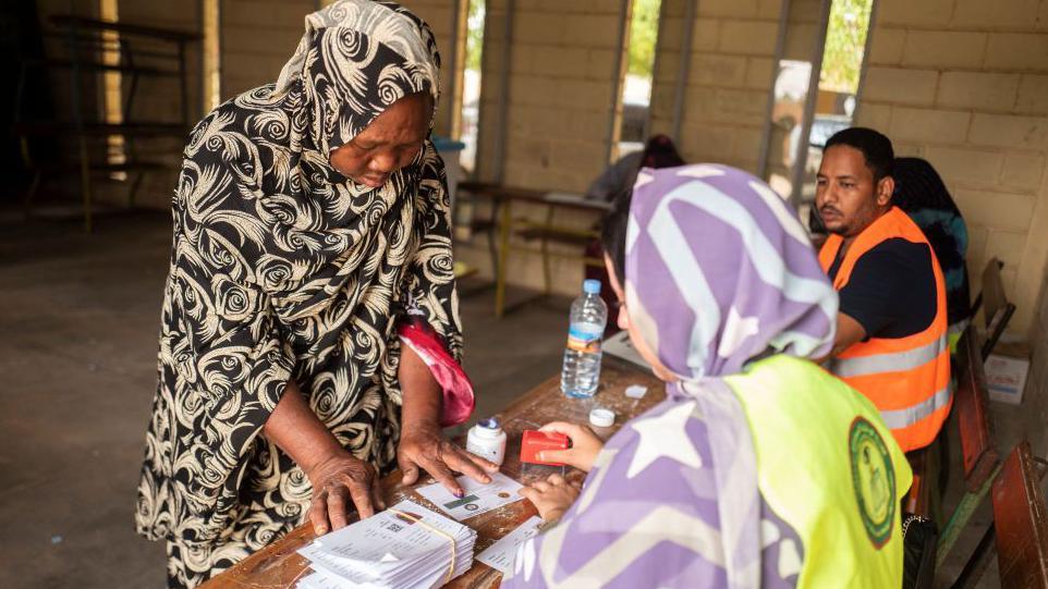 A woman marks a document with her inked finger at a voting station in Nouakchott on June 29, 2024.