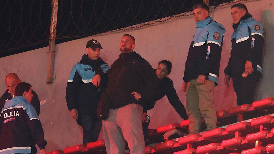 Injured fan being attended to by police after violence in a game between Independiente and Universidad de Chile