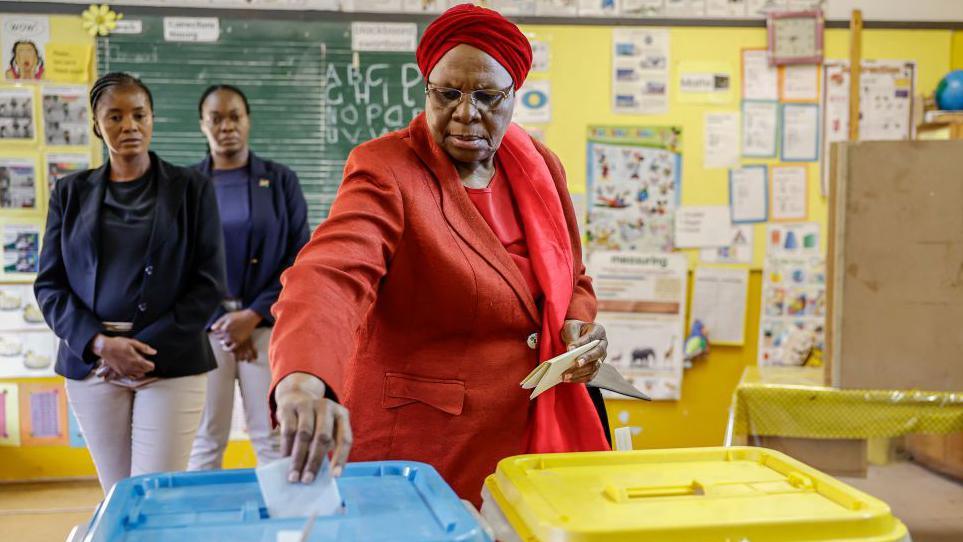 Namibia ruling party Swapo presidential candidate Netumbo Nandi-Ndaitwah in a red suit casting her ballot at a polling centre