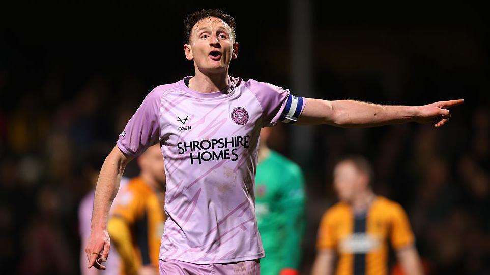 Shrewsbury Town defender Will Boyle shouts and points to team mates during a match