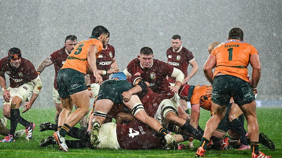Players battle for the ball in heavy rain