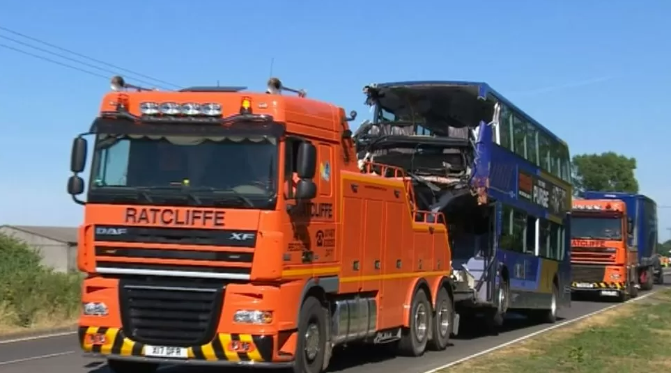 The damaged bus being towed from the crash site