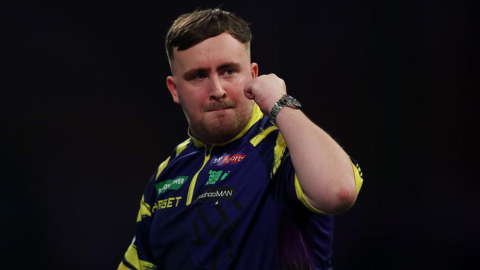 Luke Littler holds up his fist to celebrate