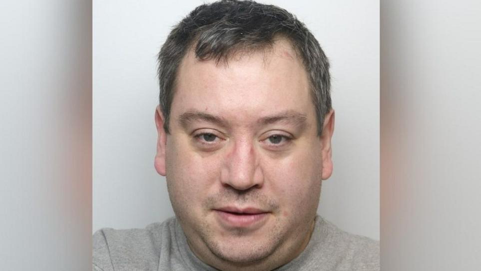 Graham Dowling looking at the camera with his mouth slightly open. He has short, greying hair and slight stubble.