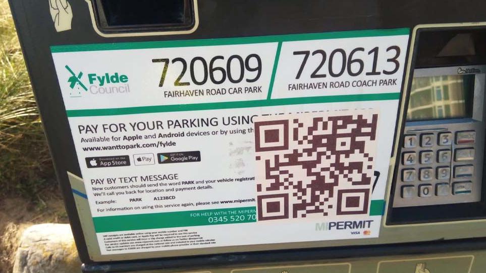 Parking sign showing a bogus QR sticker