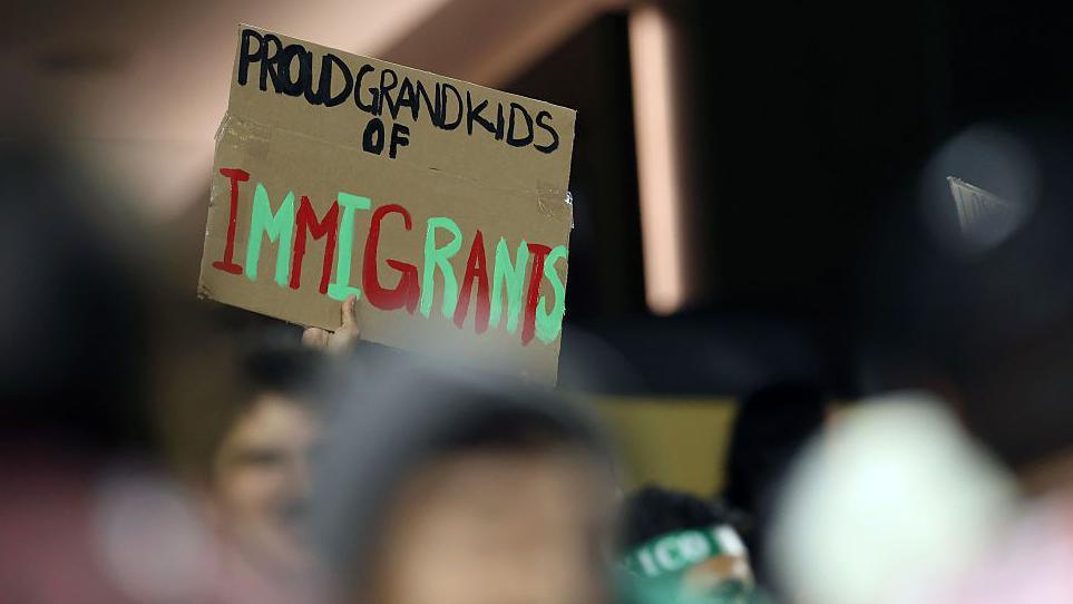 A fan holding a sign at Mexico's Gold Cup game against the Dominican Republic, which reads 'proud grandkids of immigrants'