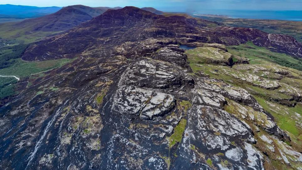 An aerial picture of the Rhinogydd mountain range, showing a vast area of hillsides burnt out by fire.