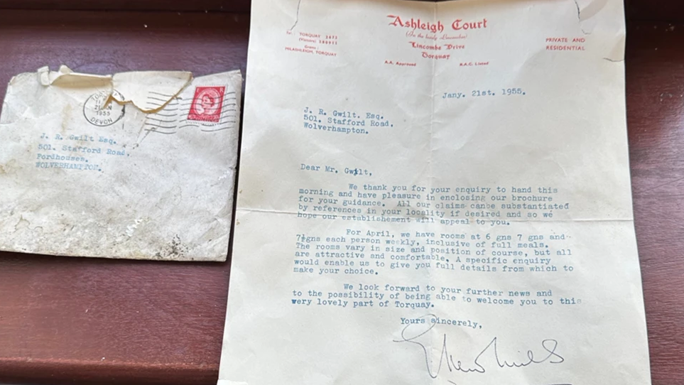 The letter is laid out on a table next to its envelope. It is on letterheaded paper from the hotel, Ashleigh Court, and typed with a signature at the bottom.
