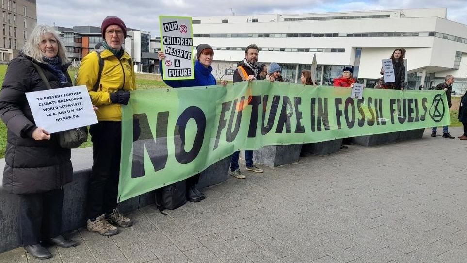 Extinction Rebellion protestors outside Lincolnshire Energy Conference, holding up a banner saying "No future in fossil fuels"