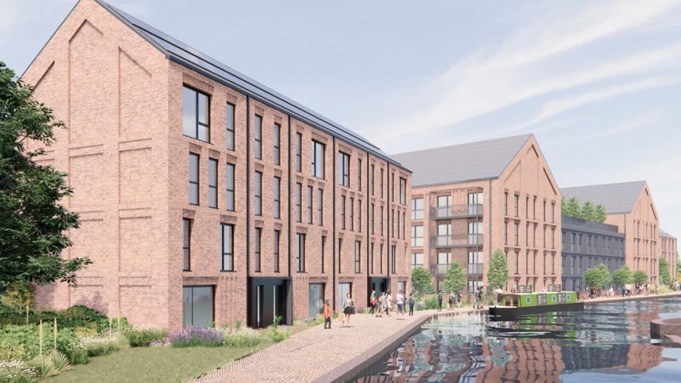 Artist impression of the canal development shows three buildings of apartments next to the canal with people walking by the side of the water. There are flowers and grass to one side with light red brick buildings with windows spanning one side of the canal. Some trees can be seen following the development by the canal.